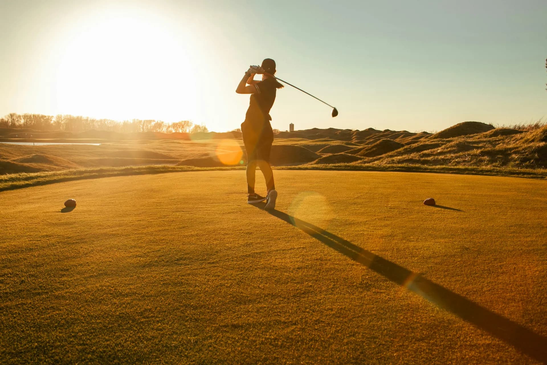 Golfer silhouetted at golden hour